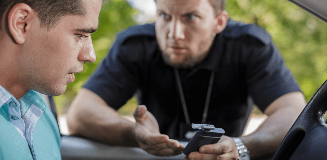 Police officer holding a breathalyzer, questioning a concerned driver during a roadside sobriety check