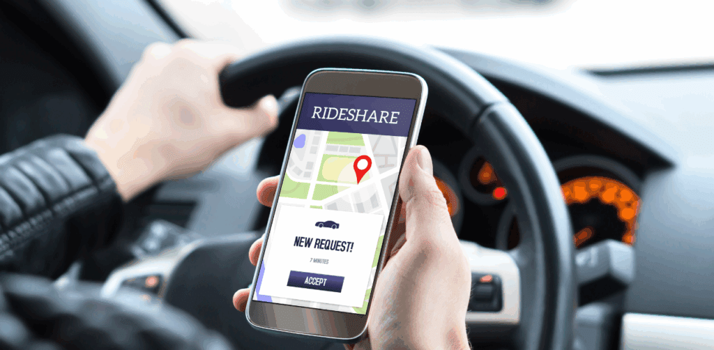 Close-up of a driver holding a phone with a rideshare app showing a new ride request and map location