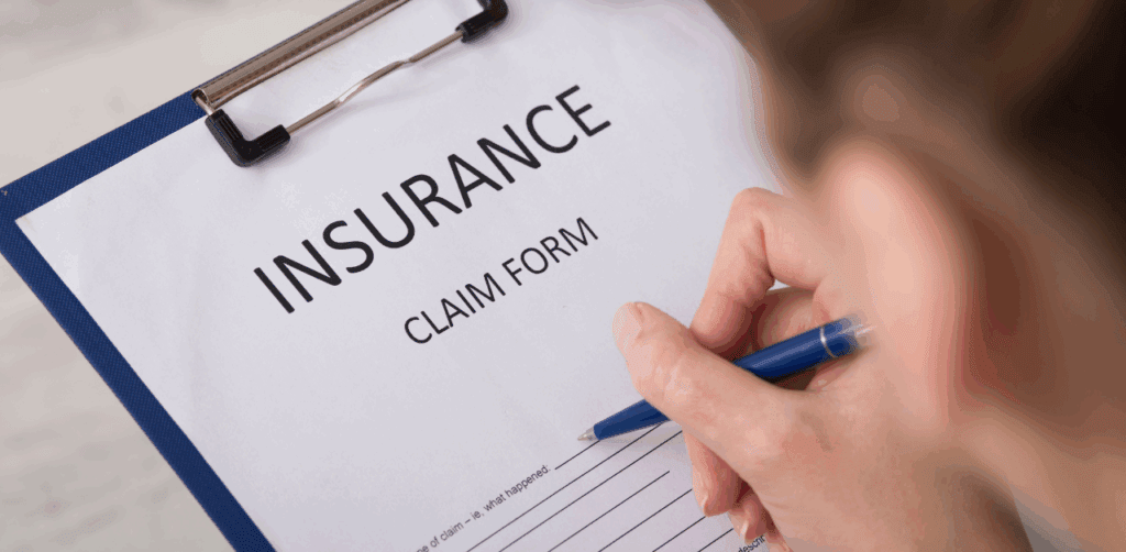 Handwriting on an insurance claim form clipped to a clipboard, representing accident or damage documentation