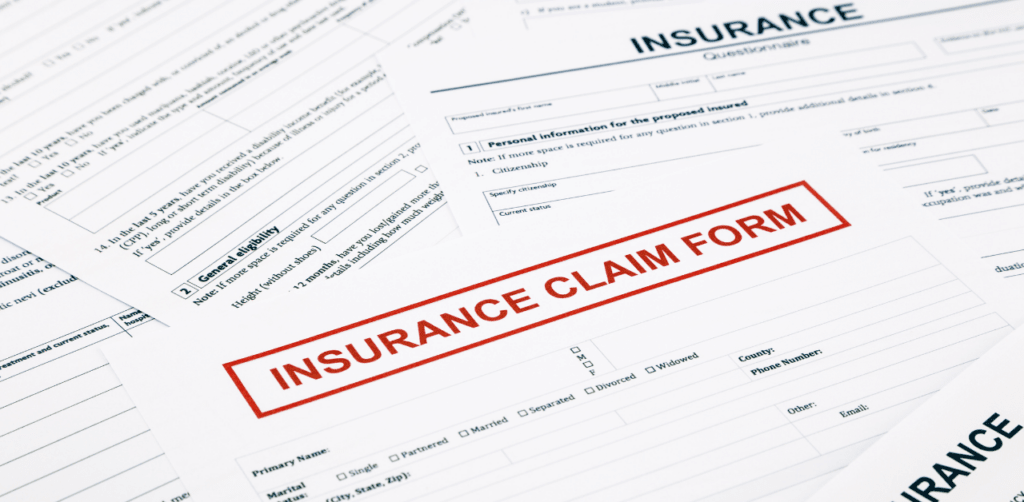 Stack of insurance claim forms spread out on a table